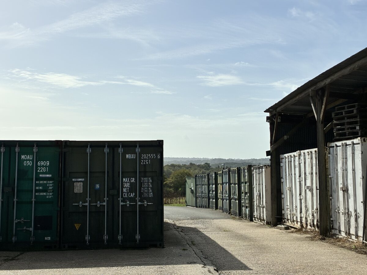 Green and white outdoor storage units beside the warehouse
