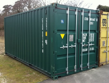 A blue 20ft steel shipping container standing in a gravel yard